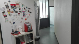 Hall d'entrée des Bureaux de Bordo Buro avec machine à café et vue sur les bureaux